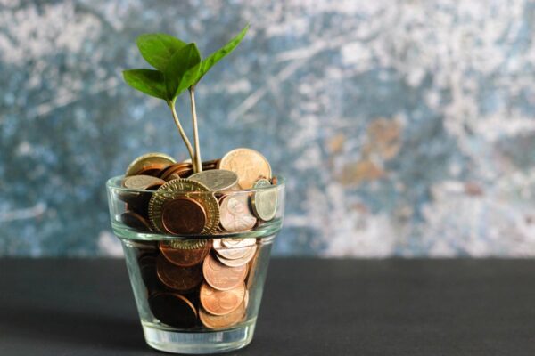 tangentretirement-What-is-a-Mega-Backdoor-Roth-401k-photo-of-coins-in-a-glass-jar-with-plant-in-it
