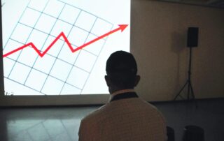 photo of a man looking at the inflation rates on a big screen